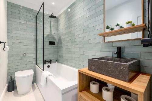 a bathroom with a sink and a tub and a toilet at The Victorian House - Enticing 3BDR House with Garden in Oxford