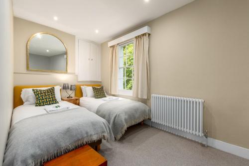 1 dormitorio con 2 camas y ventana en The Victorian House - Enticing 3BDR House with Garden en Oxford