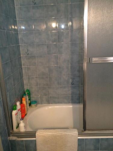 a bathroom with a bath tub with blue tiles at Primera línea aguas termales zen in Comarruga