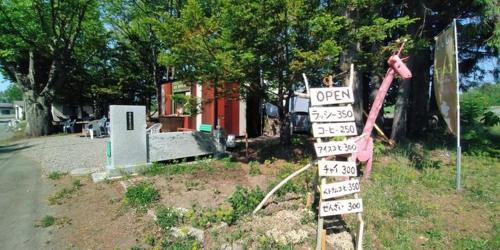 a sign in the yard next to a house at Mizu no Gakko in Shari