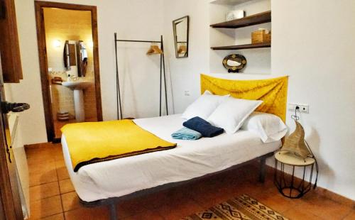 um quarto com uma cama branca e um cobertor amarelo em Entre Dos Aguas em Granada