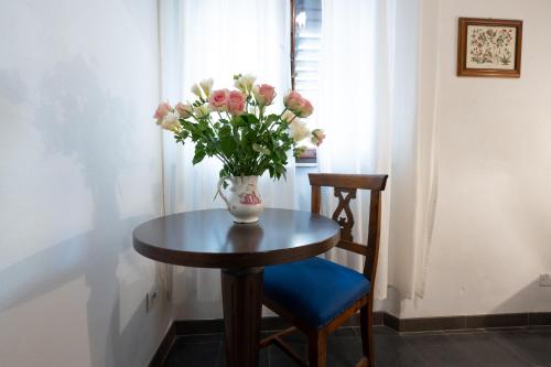 a vase of flowers sitting on a table with a chair at Affittacamere Le camerine di Silvia 2 in Siena