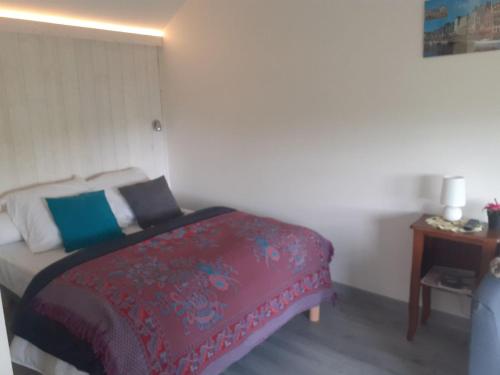 um quarto com uma cama com um cobertor vermelho e azul em Maison d'hôtes indépendante à la campagne em Ablon