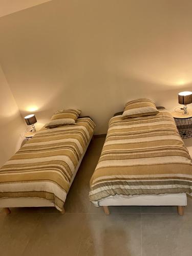 Duas camas sentadas uma ao lado da outra num quarto em Paname ou Rouen ? em Freneuse