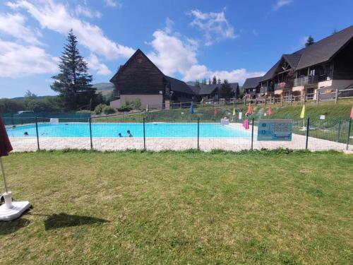 - une piscine avec des personnes à l'eau dans l'établissement Super Besse 5/6 pers. Vue sur les monts du cantal, à Besse-et-Saint-Anastaise