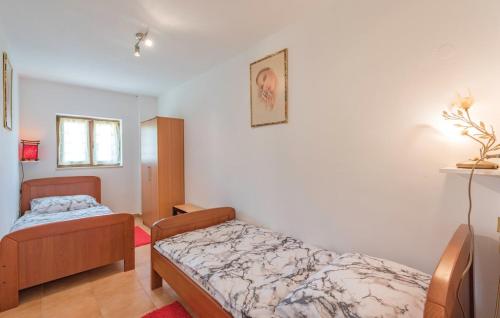 1 dormitorio con 2 camas en una habitación en Apartman Aja, en Kaštelir