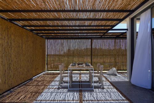 a table and chairs on a patio with a wooden ceiling at Bouca Houses in Messini