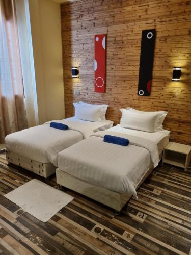 two beds sitting next to each other in a room at Thundi Village & Spa in Maalhos