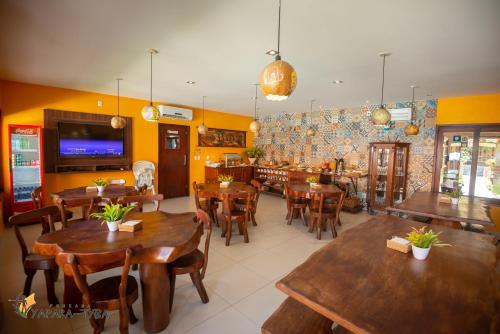 雅帕拉廷加的住宿－Pousada Yapara-Tyba，一间设有木桌和椅子的餐厅