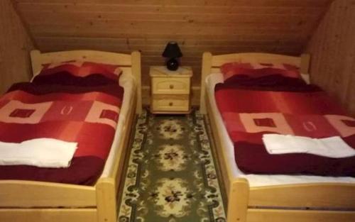 two beds in a room with a nightstand and two beds sidx sidx at Chata U Juraja in Hruštín