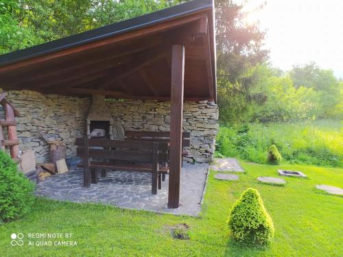 a bench under a stone building with a fireplace at Chata U Juraja in Hruštín
