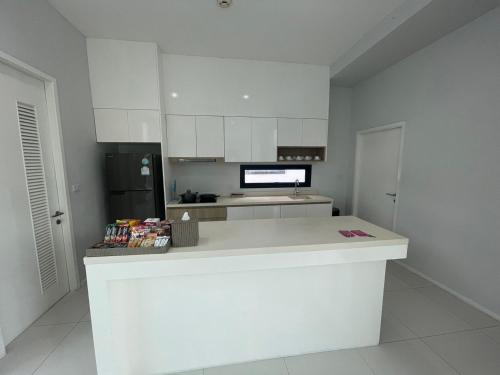 a kitchen with white cabinets and a white counter top at Movenpick Pool Villa by Hello Pattaya in Na Jomtien