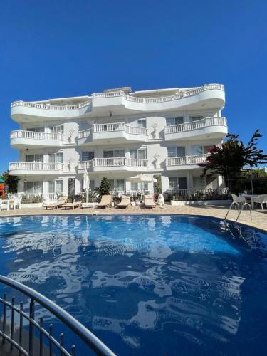 - un grand bâtiment avec une grande piscine en face dans l'établissement Belka Golf Residence Delux apt Poolside, à Belek