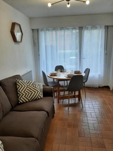 un salon avec un canapé, une table et des chaises dans l'établissement Appartement avec terrasse centre samoens, à Samoëns