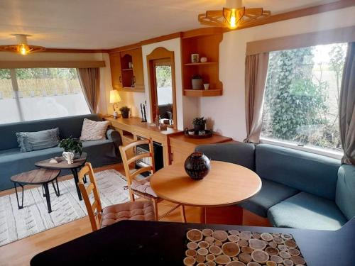 ein Wohnzimmer mit einem blauen Sofa und einem Tisch in der Unterkunft Delightful tiny home in the middle of nature. 