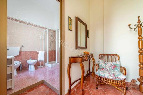 uma casa de banho com um chuveiro, uma cadeira e um WC. em Locazione turistica Lorusso em Andria
