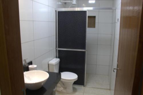 W łazience znajduje się toaleta, umywalka i prysznic. w obiekcie Sobrado espaçoso com piscina com ar na suite w mieście Chapada dos Guimarães