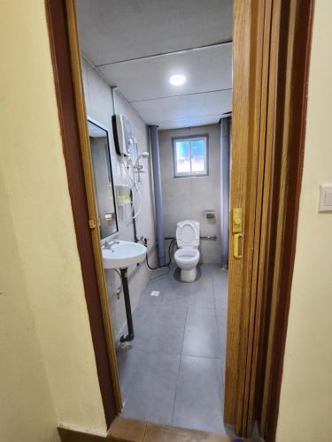 a bathroom with a toilet and a sink at LTH (Little Turtle's Home) in Semporna