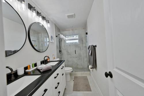 ein Badezimmer mit einem Waschbecken, einem WC und einem Spiegel in der Unterkunft Sail Away Beach Cottage Sleeps 10 Heated Pool in Fort Lauderdale