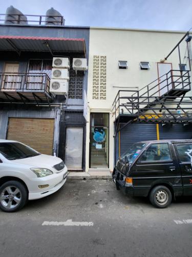 two cars parked in a parking lot in front of a building at LTH (Little Turtle's Home) in Semporna