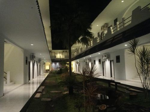 a building with a courtyard with a palm tree in it at Mahkota Hotel in Genteng-kulon