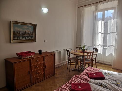 a bedroom with a table and a bed and a table and chairs at Swiss House Apartments in Slavonice