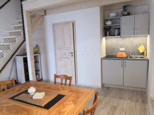 een keuken en eetkamer met een houten tafel bij Swiss House Apartments in Slavonice