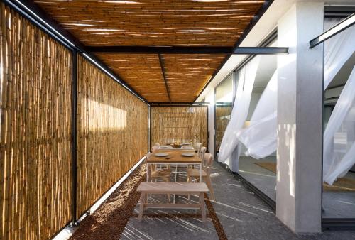 a table and chairs in a room with a wall at Bouca Houses in Messini
