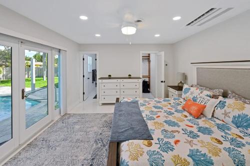 um quarto com uma cama e uma porta de vidro deslizante em Moana Beach Cottage em Fort Lauderdale
