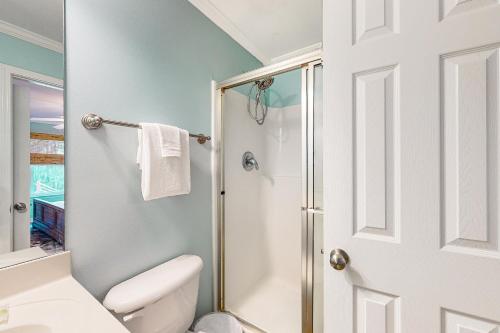 a white bathroom with a shower and a toilet at Sunset Breeze #4 in Dauphin Island