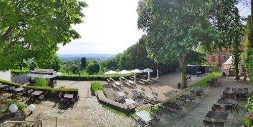 an outdoor patio with chairs and tables and umbrellas at Schlosshotel Kassel in Kassel