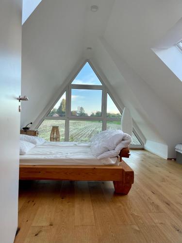 a bed in a room with a large window at Ruheoase mitten in der Natur in Wilhelmsdorf