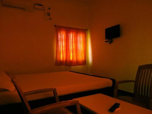 a small room with a table and a window at Srinivasa Residency in Mahabalipuram