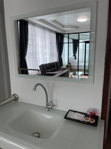 un soggiorno con specchio sopra un lavandino di Service Apartment ใจกลางเมืองใกล้แหล่งท่องเที่ยว119ทับ1ถนนปงสนุก a Lampang