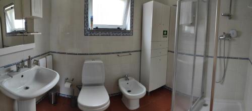a bathroom with a sink and a toilet and a shower at Casa dos Salgueiros in Faja Grande