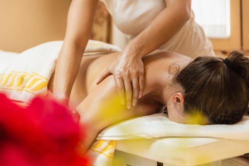 a woman laying on a bed getting a massage at Sonnenhotel Adler Spa & Nature Adults only in Villandro