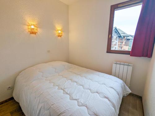 a bedroom with a white bed and a window at Appartement 2/4 pers, Résidence 4* Les Hauts de Valmeinier, Centre station in Valmeinier