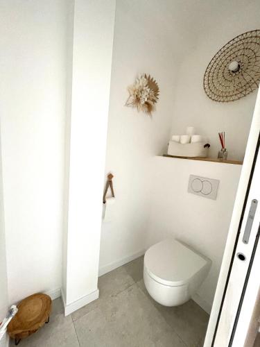 a white bathroom with a toilet and a mirror at Ty kaz : élégant, tout confort et bien situé in Névez