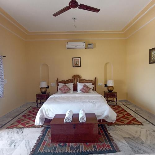 a bedroom with a bed and a ceiling fan at Fort Chabariya in Kekri