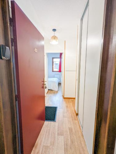 un couloir avec une porte menant à une chambre dans l'établissement Appartement 2/4 pers, Résidence 4* Les Hauts de Valmeinier, Centre station, à Valmeinier