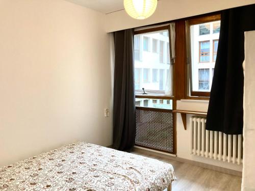 une chambre avec un lit et une grande fenêtre dans l'établissement F3 au cœur du centre de Metz, à Metz