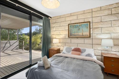 a bedroom with a large bed and a balcony at Moggs Magic in Aireys Inlet