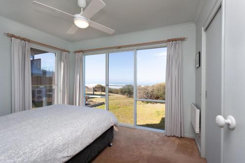 a bedroom with a bed and a large window at Moggs View in Aireys Inlet