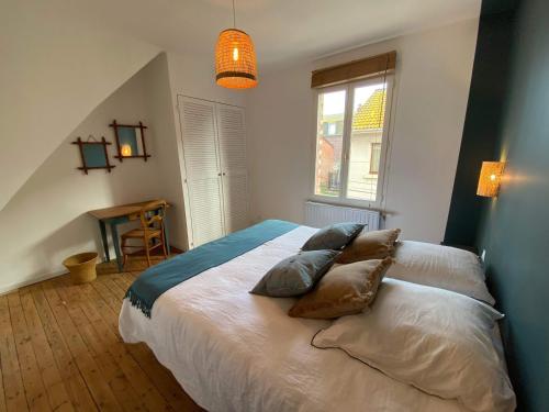 a bedroom with a large bed with pillows on it at Gaston in Mers-les-Bains