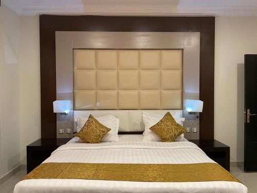 a bedroom with a large bed with gold pillows at Al Deyafah Narjis-الضيافة نرجس in Khamis Mushayt