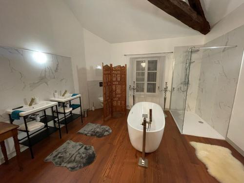 a bathroom with a tub and two sinks and a shower at Le Domaine d'Élise Chambres et table d'hôtes - Vosges in Saint-Ouen-lès-Parey
