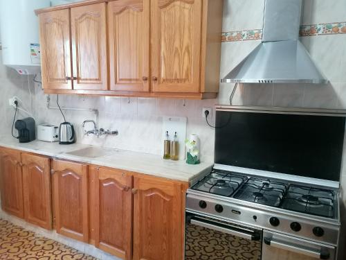 a kitchen with wooden cabinets and a stove top oven at Casa do Cabeço - Termas da Sulfúrea in Cabeço de Vide