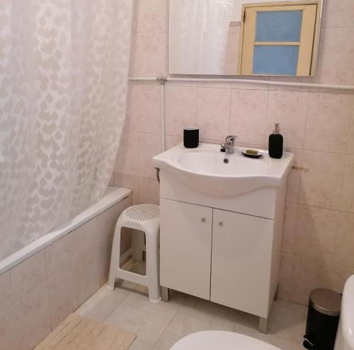 La salle de bains blanche est pourvue d'un lavabo et d'une douche. dans l'établissement Casa do Cabeço - Termas da Sulfúrea, à Cabeço de Vide