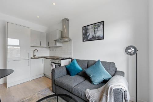 uma sala de estar com um sofá e uma cozinha em Lovely 1 Bedroom with outdoor space em Londres