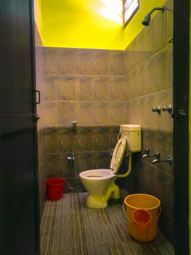 a bathroom with a toilet with buckets in it at Srinivasa Residency in Mahabalipuram